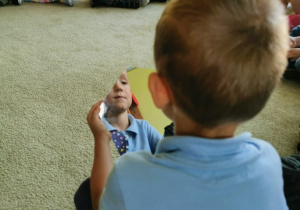 Chłopiec patrzy w swoje odbicie w lustrze